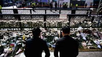 Tak sedikit pula yang datang dengan membawa bunga dan berbagai hadiah belasungkawa. Mulai dari permen hingga botol soju. Foto: AFP via Getty Images/ANTHONY WALLACE