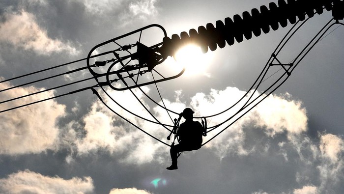 LIANYUNGANG, CHINA - SEPTEMBER 28: An electrician carries out maintenance work on electric wires of a 500KV transmission line project on September 28, 2022 in Lianyungang, Jiangsu Province of China. (Photo by Geng Yuhe/VCG via Getty Images)