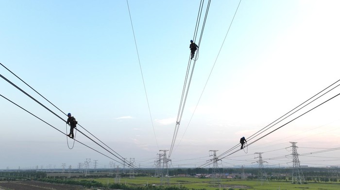 LIANYUNGANG, CHINA - SEPTEMBER 28: An electrician carries out maintenance work on electric wires of a 500KV transmission line project on September 28, 2022 in Lianyungang, Jiangsu Province of China. (Photo by Geng Yuhe/VCG via Getty Images)