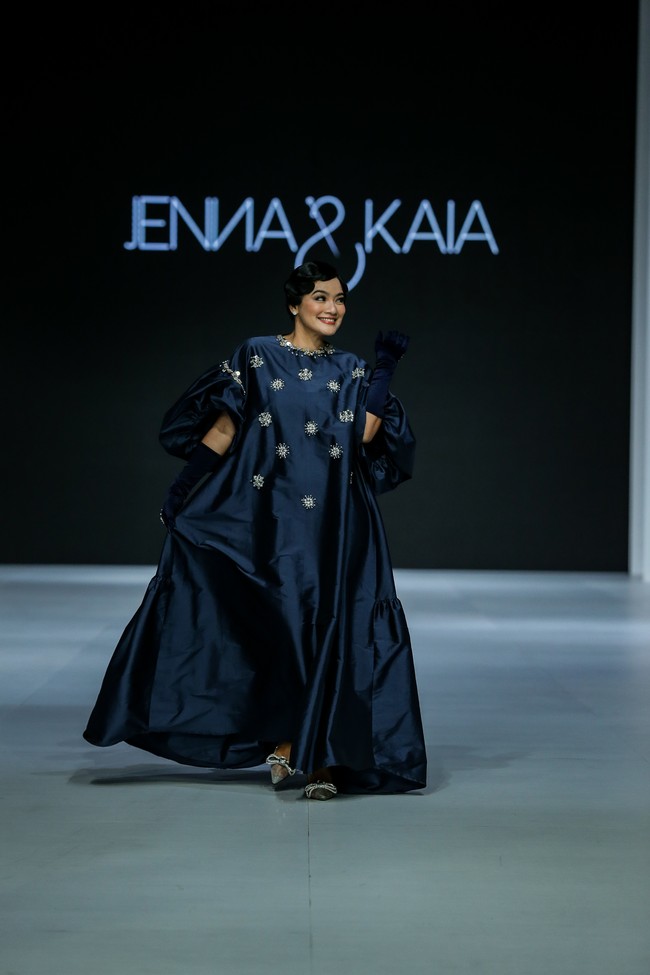 Pada hari yang sama, tampil pula Titi Kamal dengan gaun midnight blue bersiluet kaftan dari label Jenna & Kaia. (Foto: Dachri Megantara/Jakarta Fashion Week)