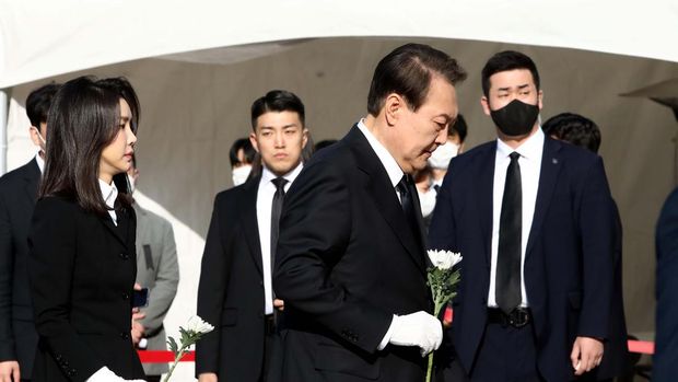 SEOUL, SOUTH KOREA - OCTOBER 31:  South Korean President Yoon Suk-yeol and his wife Kim Kun-hee hold flowers at a memorial altar for the victims of the Halloween celebration stampede, in front of City Hall on October 31, 2022 in Seoul, South Korea. One hundred and fifty-one people have been reported killed and at least 150 others were injured in a deadly stampede in Seoul's Itaewon district, after huge crowds of people gathered for Halloween parties, according to fire authorities. (Photo by Chung Sung-Jun/Getty Images)
