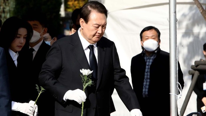 SEOUL, SOUTH KOREA - OCTOBER 31:  South Korean President Yoon Suk-yeol and his wife Kim Kun-hee hold flowers at a memorial altar for the victims of the Halloween celebration stampede, in front of City Hall on October 31, 2022 in Seoul, South Korea. One hundred and fifty-one people have been reported killed and at least 150 others were injured in a deadly stampede in Seouls Itaewon district, after huge crowds of people gathered for Halloween parties, according to fire authorities. (Photo by Chung Sung-Jun/Getty Images)