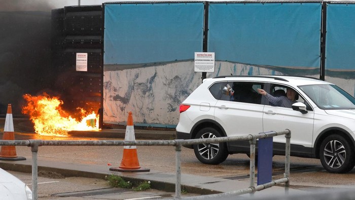 Immigration and police officers stand next to a car believed to have been used in a petrol bomb attack on the Border Force processing centre in Dover, Britain, October 30, 2022.  REUTERS/Peter Nicholls