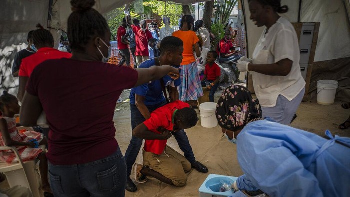 Medical personnel attend patients with cholera symptoms at a clinic run by Doctors Without Borders in Port-au-Prince, Haiti, Thursday, Oct. 27, 2022. For the first time in three years, people in Haiti have been dying of cholera, raising concerns about a potentially fast-spreading scenario and reviving memories of an epidemic that killed nearly 10,000 people a decade ago. (AP Photo/Ramon Espinosa)