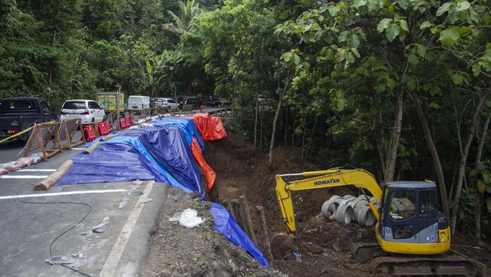 JALAN LONGSOR DI YOGYAKARTA Pengendara sepeda motor melintas di jalur utama Yogyakarta - Wonosari yang longsor di Piyungan, Bantul, DI Yogyakarta, Senin (31/10/2022). Jalan utama penghubung Kota Yogyakarta dan Kabupaten Gunungkidul itu longsor dan menghancurkan separuh jalan yang diakibatkan oleh tingginya curah hujan beberapa pekan ini. ANTARA FOTO/Hendra Nurdiyansyah/hp.