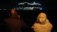 Warga melihat kapal pesiar MSC World Europa meninggalkan pelabuhan Saint-Nazaire, Prancis barat, Rabu (26/10/2022). (Sebastien Salom-Gomis/AFP/Getty Images)  