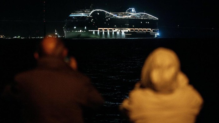 Warga melihat kapal pesiar MSC World Europa meninggalkan pelabuhan Saint-Nazaire, Prancis barat, Rabu (26/10/2022). (Sebastien Salom-Gomis/AFP/Getty Images)