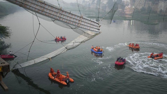 Search and rescue work is conducted after a cable suspension bridge collapsed in Morbi town of western state Gujarat, India, Monday, Oct. 31, 2022. The century-old cable suspension bridge collapsed into the river Sunday evening, sending hundreds plunging in the water, officials said. (AP Photo/Ajit Solanki)