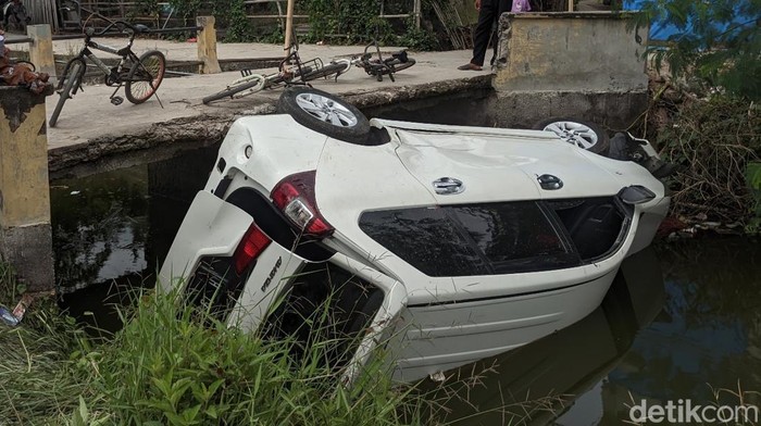 Mobil terguling di sungai wilayah Demak, Senin (31/10/2022). Mobil itu diduga dinaiki maling sepeda.