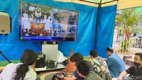 Warga menyaksikan jalannya sidang lewat televisi.
