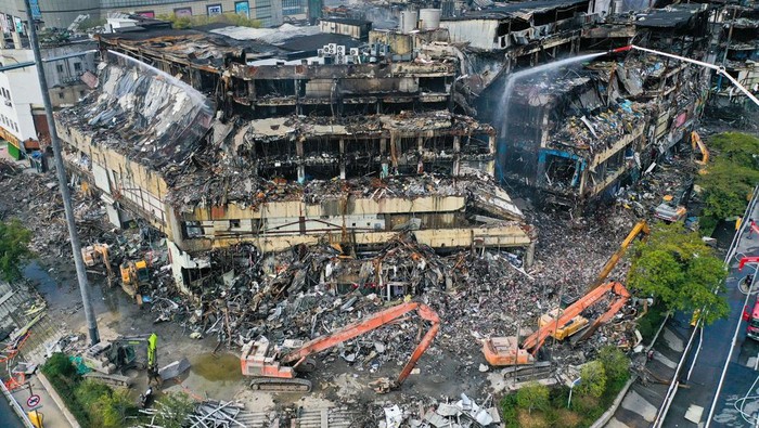 NANJING, CHINA - OCTOBER 31, 2022 - A high-jet fire engine sprays water on the building at the site, more than 50 hours after a fire broke out at Jinsheng department store in Nanjing, Jiangsu Province, China, Oct 31, 2022. (Photo credit should read CFOTO/Future Publishing via Getty Images)