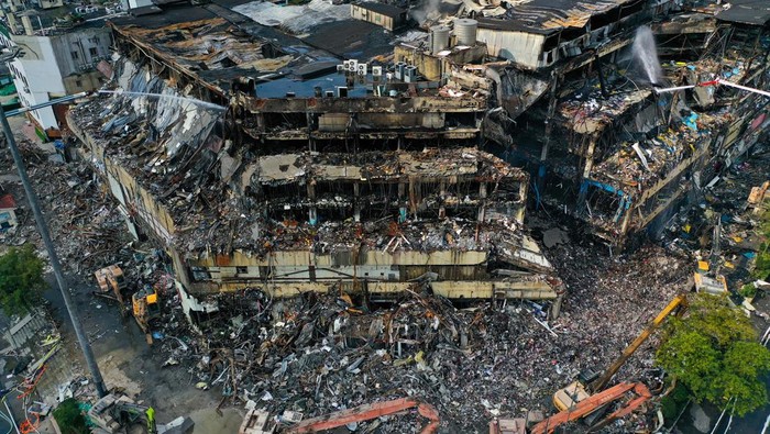 NANJING, CHINA - OCTOBER 31, 2022 - A high-jet fire engine sprays water on the building at the site, more than 50 hours after a fire broke out at Jinsheng department store in Nanjing, Jiangsu Province, China, Oct 31, 2022. (Photo credit should read CFOTO/Future Publishing via Getty Images)