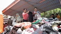 Terlihat warga sedang memilah pakian layak pakai hasil sumbangan warga sekitar.