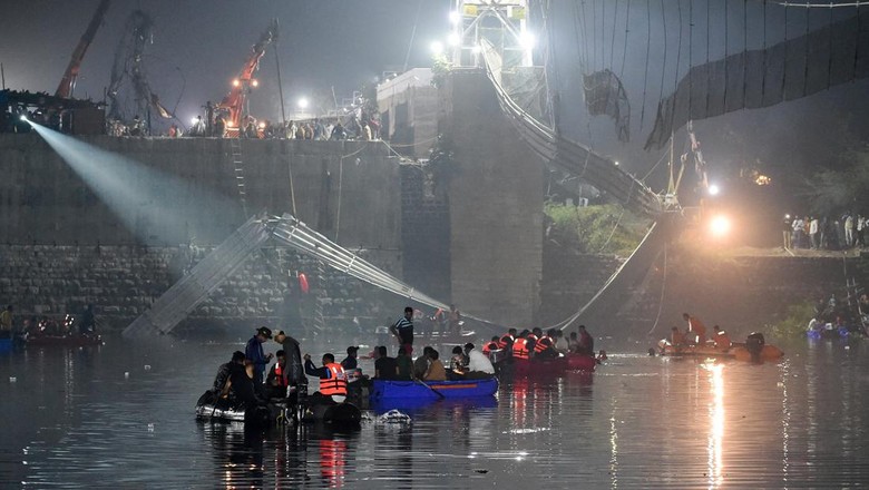 Rescue personnel conduct search operations after a bridge across the river Machchhu collapsed at Morbi in Indias Gujarat state on October 31, 2022. - At least 130 people were killed in India after a colonial-era pedestrian bridge collapsed, sending scores of people tumbling into the river below, police said on October 31. (Photo by Sam PANTHAKY / AFP) (Photo by SAM PANTHAKY/AFP via Getty Images)