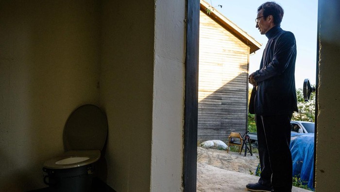 This picture taken on October 17, 2022 shows architecture professor Lee Tae-goo opening a hatch door as he prepares to climb out of his bunker, which is buried one metre (three feet) deep and can protect from the radiation fallout of a nuclear blast on his property in Jecheon, some 74 miles (120 km) southeast of the capital Seoul. - If North Korea unleashes a nuclear attack on the South, architecture professor Lee Tae-goo plans to retreat to his purpose-built bunker -- which was funded by a government grant -- and stay underground for at least two weeks to avoid radiation poisoning. - To go with 'SKOREA-NKOREA-NUCLEAR-BUNKER,FOCUS' by Cat Barton and Kang Jin-kyu (Photo by Anthony WALLACE / AFP) / To go with 'SKOREA-NKOREA-NUCLEAR-BUNKER,FOCUS' by Cat Barton and Kang Jin-kyu (Photo by ANTHONY WALLACE/AFP via Getty Images)