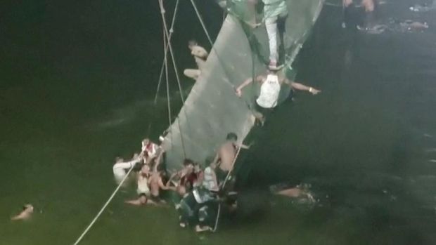 Setidaknya 60 orang tewas setelah satu jembatan gantung di India yang sudah berusia 100 tahun ambruk pada Minggu (30/10). (via REUTERS/ANI)