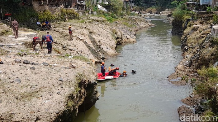 Tim SAR gabungan memasang jaring hingga menyelam untuk mencari bocah laki-laki yang hilang terbawa arus saat berenang di Sungai Ciliwung Kota Bogor. (M Sholihin/detikcom)