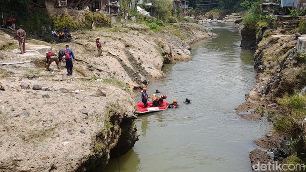 Tim SAR gabungan memasang jaring hingga menyelam untuk mencari bocah laki-laki yang hilang terbawa arus saat berenang di Sungai Ciliwung Kota Bogor. (M Sholihin/detikcom)