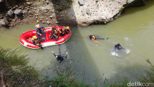 Tim SAR gabungan memasang jaring hingga menyelam untuk mencari bocah laki-laki yang hilang terbawa arus saat berenang di Sungai Ciliwung Kota Bogor. (M Sholihin/detikcom)