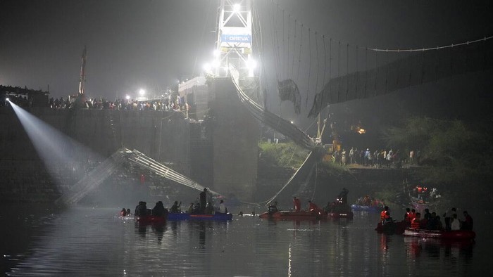 Tim penyelamat di kapal mencari korban ambruknya jembatan kabel di sungai Machchu, negara bagian barat Gujarat, India, Senin (31/10/2022) waktu setempat. Sebanyak 81 orang tewas.