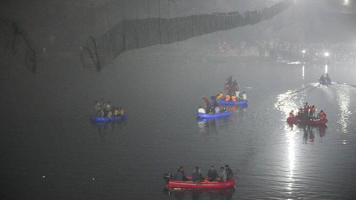 Usai Itaewon, 81 Orang Tewas Akibat Jembatan Gantung Ambruk di India Tim penyelamat di kapal mencari korban ambruknya jembatan kabel di sungai Machchu, negara bagian barat Gujarat, India, Senin (31/10/2022) waktu setempat.