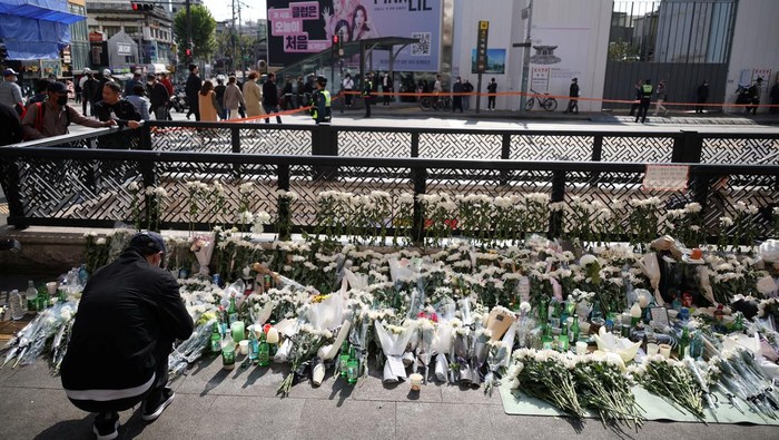 Mourners attend a floral tribute near the scene of a crowd crush that happened during Halloween festivities, in Seoul, South Korea, November 1, 2022. REUTERS/Kim Hong-Ji