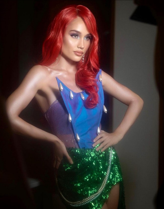 Cinta Laura yang mengidolakan karakter Putri Ariel juga berdandan seperti putri duyung. Ia tampil seksi bak Little Mermaid dengan kemben ungu hologram, rok mini dan wig merah. Foto: Instagram