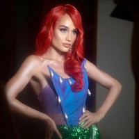 Cinta Laura yang mengidolakan karakter Putri Ariel juga berdandan seperti putri duyung. Ia tampil seksi bak Little Mermaid dengan kemben ungu hologram, rok mini dan wig merah. Foto: Instagram