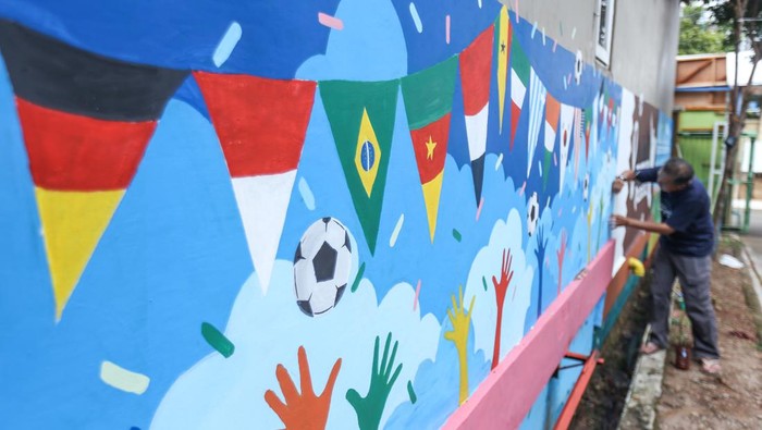 Jelang Piala Dunia, Warga Depok Bikin Mural-Pasang Bendera di Komplek eorang warga membuat mural di dinding di Perumahan Maharaja Cluster Cemara, Rangkapan Jaya, Depok, Jawa Barat, Selasa (1/11/2022). Perumahan ini diberi nama Kampung Piala Dunia.
