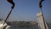 Para pekerja menggunakan mesin untuk memindahkan puing-puing jembatan penyeberangan yang runtuh di kota Morbi di negara bagian barat Gujarat, India, Senin, 31 Oktober 2022. AP Photo/Ajit Solanki.