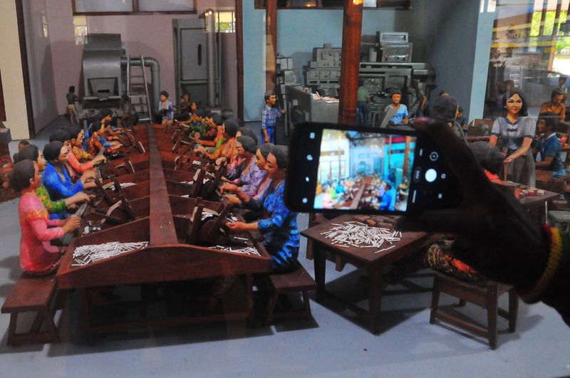 Pengunjung mengabadikan diorama pembuatan rokok kretek. Museum ini menyimpan lebih dari 1.195 koleksi, seperti peralatan tradisional dan benda-benda promosi rokok di masa lalu serta diorama proses pembuatan rokok hingga foto-foto para pendiri pabrik kretek dan hasil produksinya.