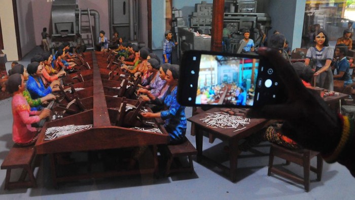 Pengunjung mengabadikan diorama pembuatan rokok kretek. Museum ini menyimpan lebih dari 1.195 koleksi, seperti peralatan tradisional dan benda-benda promosi rokok di masa lalu serta diorama proses pembuatan rokok hingga foto-foto para pendiri pabrik kretek dan hasil produksinya.