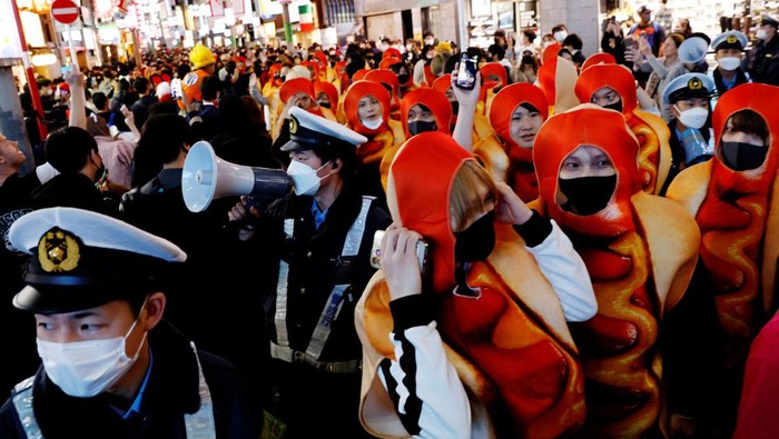 Security guards patrol to control crowds gathering to celebrate Halloween on the street at Tokyos Shibuya entertainment and shopping district in Tokyo, Japan October 31, 2022. REUTERS/Kim Kyung-Hoon