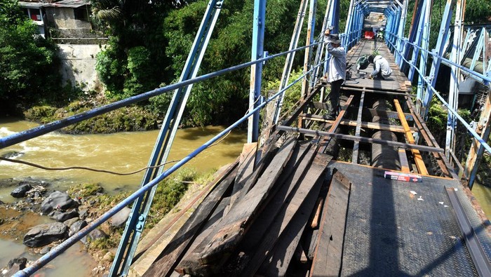 Penampakan jembatan yang dibongkar pekerja. Jembatan ini dibangun pada jaman Belanda di atas Sungai Cisadane .