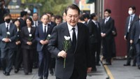 Presiden Korea Selatan Yoon Suk-yeol memegang bunga saat mendatangi lokasi tragedi pesta Halloween Itaewon, Korea Selatan, Selasa (1/11/2022). Tragedi mengerikan yang terjadi di Itaewon pada malam Halloween Sabtu (29/10/2022) malam menyisakan duka mendalam bagi siapapun.