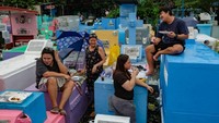 Tak hanya itu, keluarga yang berkunjung mengadakan piknik di atas makam.