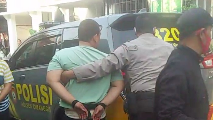 Pria berinisial RNA (31) yang tega membunuh anak sendiri secara sadis dibawa ke Polres Metro Depok. Polisi juga menyita parang yang dipakai pelaku. (dok Istimewa)