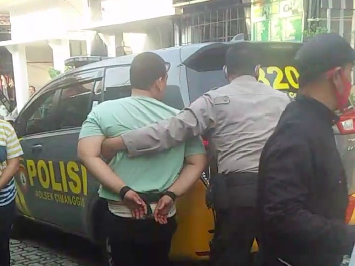 Pria berinisial RNA (31) yang tega membunuh anak sendiri secara sadis dibawa ke Polres Metro Depok. Polisi juga menyita parang yang dipakai pelaku. (dok Istimewa)