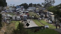 Pendukung Presiden Brasil Jair Bolsonaro berkumpul saat mereka memblokir jalan raya BR-060 di Abadiania, Brasil, Senin (31/10/2022).  