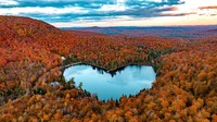 Gambar udara menunjukkan Danau Baker yang dikelilingi oleh pepohonan dengan warna musim gugur di East Bolton, Quebec.