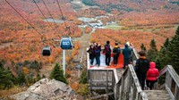 Pengunjung berfoto saat orang lain menaiki lift ski ke Mont-Orford di Taman Nasional Mont-Orford dekat Orford, Quebec.