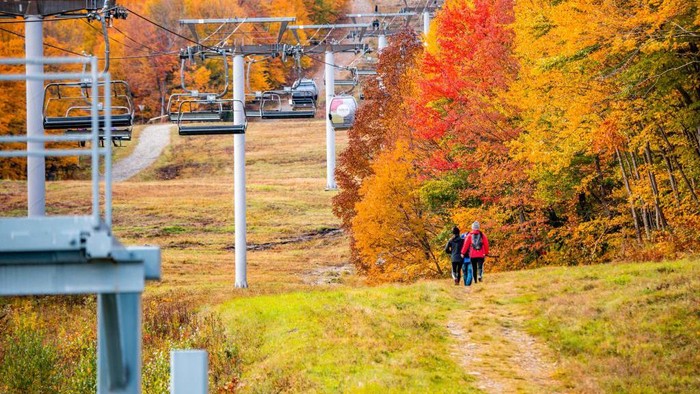 Visitors take pictures as others ride the ski-lift to Mont-Orford in the Mont-Orford National Park near Orford, Quebec, Canada, on October 8, 2022. (Photo by Sebastien ST-JEAN / AFP) (Photo by SEBASTIEN ST-JEAN/AFP via Getty Images)