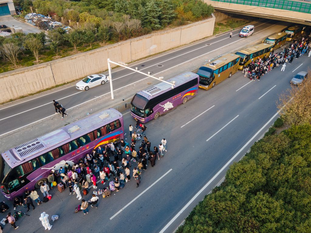 ZHENGZHOU, CHINA - OCTOBER 30: Foxconn employees take shuttle buses to head home on October 30, 2022 in Zhengzhou, Henan Province of China. Shuttle buses have been arranged by local authorities to facilitate the return trips of Foxconn factory workers to their hometowns after COVID-19 infections were reported in the city Zhengzhou. (VCG/VCG via Getty Images)