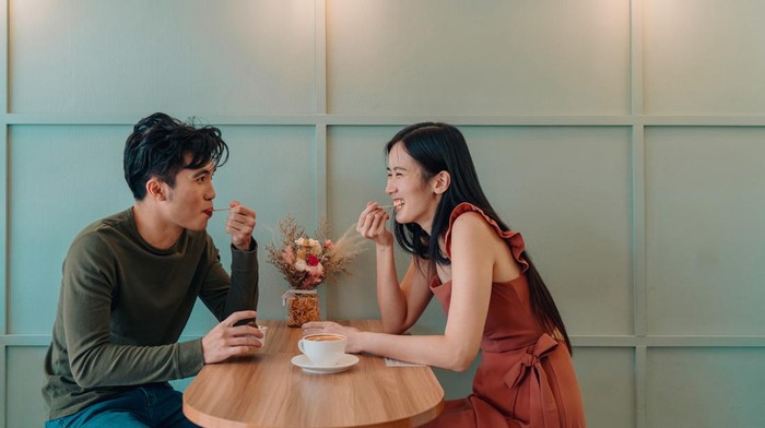Young Asian couple dating in a cafe over gelato