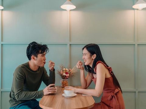 Young Asian couple dating in a cafe over gelato