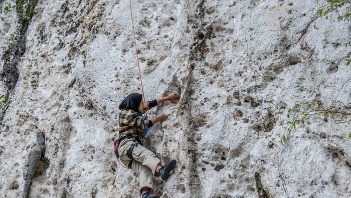 KENDARI, INDONESIA - 2022/10/30: A visitor tries to climb a karst cliff on a rock climbing tour in Konawe. Sawapudo Cliff, which has karst rock walls with a height of about 20 meters, is visited by many tourists and nature lovers as a rock climbing area. (Photo by Andry Denisah/SOPA Images/LightRocket via Getty Images)
