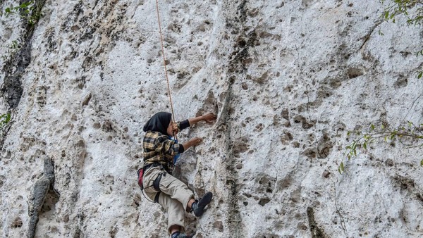 Tebing Sawapudo yang memiliki dinding batuan karst ini banyak dikunjungi wisatawan dan pecinta alam sebagai area panjat tebing. (Andry Denisah/Getty Images)  