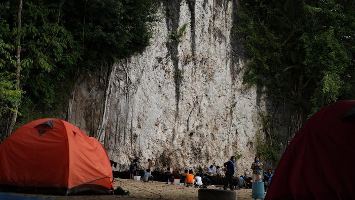 Sejumlah pengunjung berada di bawah tebing karst Sawapudo di Kecamatan Soropia, Konawe, Sulawesi Tenggara, Sabtu (29/10/2022). Tebing Sawapudo yang memiliki dinding batuan karst dengan tinggi sekitar 20 meter itu banyak dikunjungi wisatawan dan pecinta alam sebagai area panjat tebing. ANTARA FOTO/Jojon/tom.