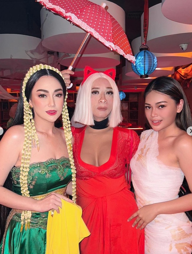 Dalam foto-foto yang diunggah terlihat Aming yang tampil mengenakan rambut palsu pendek berwarna putih yang dipadukan dengan dress seksi berpotongan dada rendah berwarna merah. Dress tersebut tampak jelas memperlihatkan belahan payudara prostetik yang dikenakan oleh Aming. Foto: Instagram/@amingisback