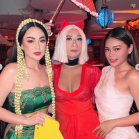 Dalam foto-foto yang diunggah terlihat Aming yang tampil mengenakan rambut palsu pendek berwarna putih yang dipadukan dengan dress seksi berpotongan dada rendah berwarna merah. Dress tersebut tampak jelas memperlihatkan belahan payudara prostetik yang dikenakan oleh Aming. Foto: Instagram/@amingisback